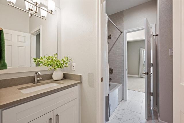 bathroom featuring a chandelier, vanity, and tiled shower / bath