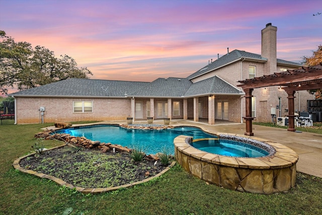 pool at dusk featuring an in ground hot tub, a yard, a pergola, and a patio