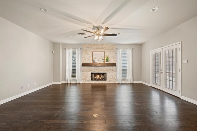 unfurnished living room with a fireplace, ceiling fan, french doors, and dark wood-type flooring