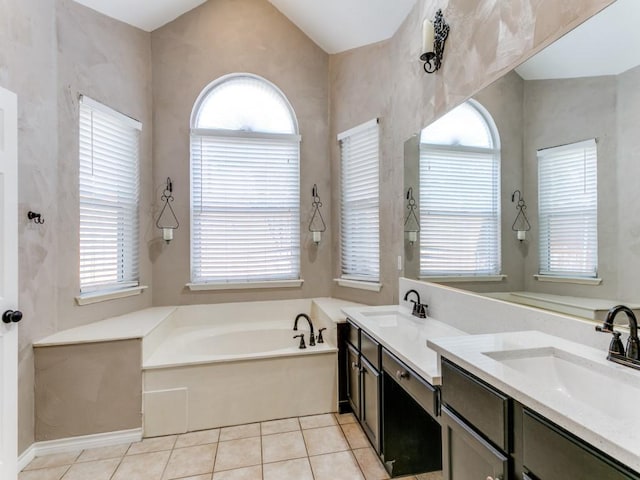 bathroom with tile patterned floors, vanity, a tub to relax in, and a wealth of natural light