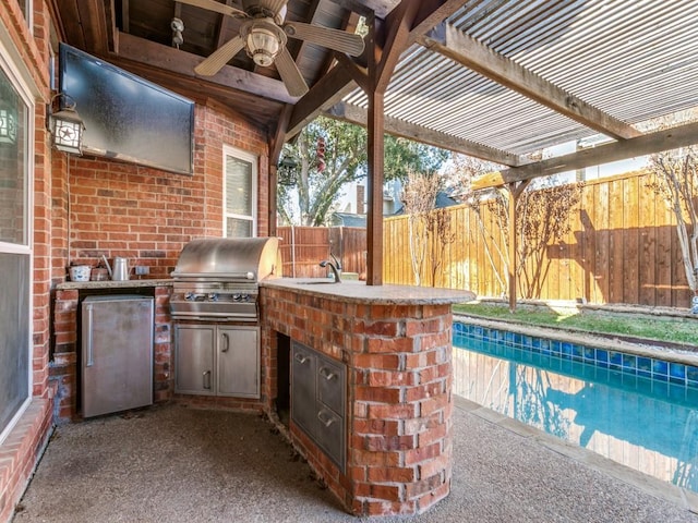 view of patio featuring ceiling fan, sink, exterior kitchen, grilling area, and a fenced in pool