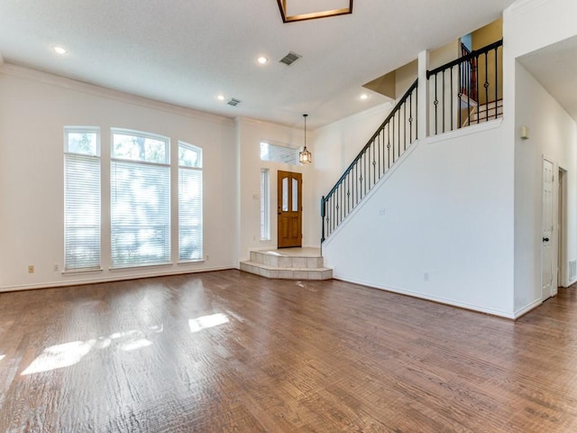 unfurnished living room with hardwood / wood-style floors and ornamental molding