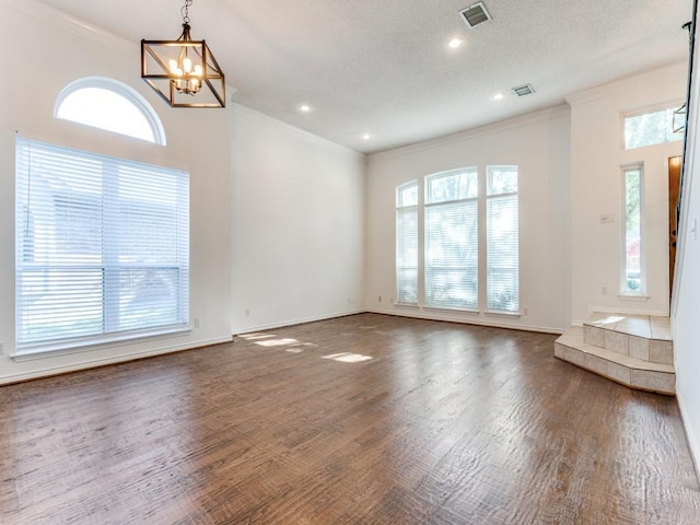 interior space featuring a chandelier, a textured ceiling, crown molding, and dark wood-type flooring