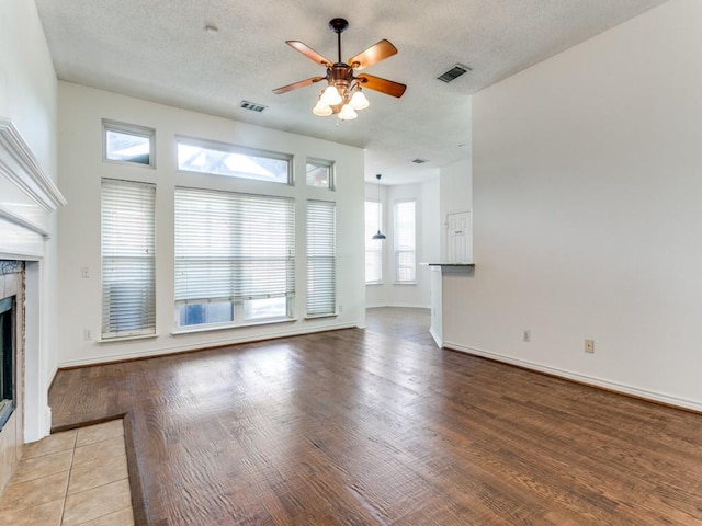 unfurnished living room with a textured ceiling, light hardwood / wood-style flooring, and plenty of natural light