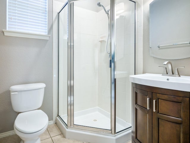 bathroom featuring tile patterned floors, vanity, toilet, and a shower with door