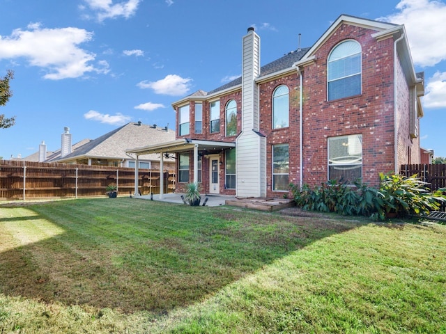 back of house with a yard and a patio