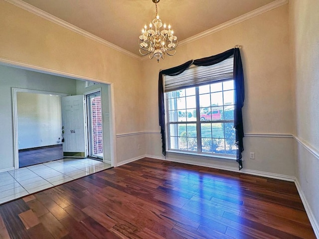 unfurnished room featuring hardwood / wood-style flooring, crown molding, and an inviting chandelier