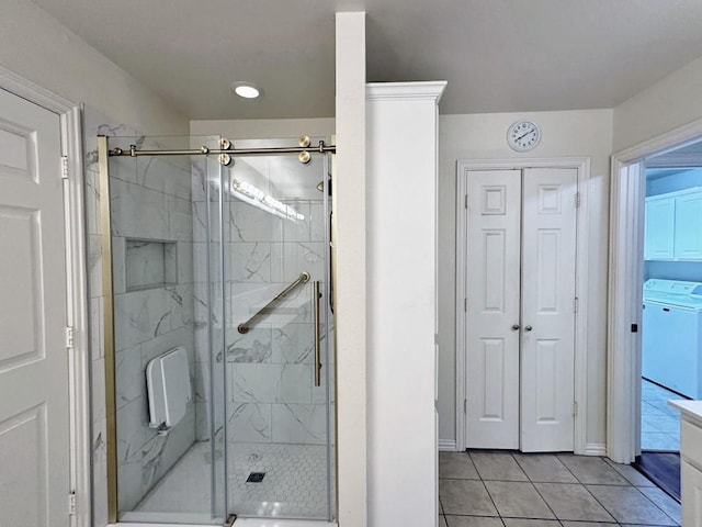 bathroom featuring tile patterned floors, washer / dryer, and walk in shower