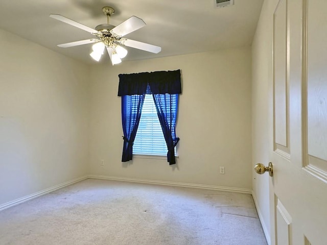 empty room featuring ceiling fan and light carpet