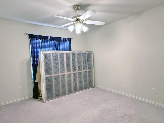 carpeted spare room featuring ceiling fan