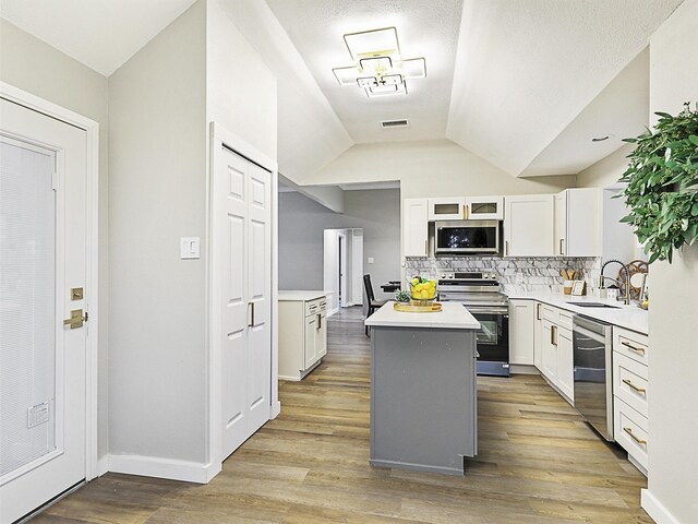 kitchen featuring white cabinets, a kitchen island, sink, and appliances with stainless steel finishes