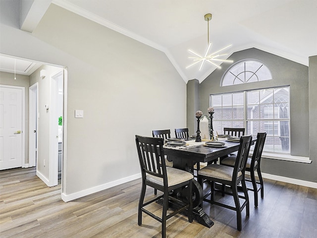 dining room featuring wood-type flooring, vaulted ceiling, and ornamental molding