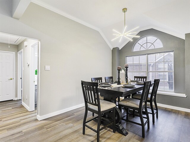 dining area featuring lofted ceiling, hardwood / wood-style floors, and an inviting chandelier