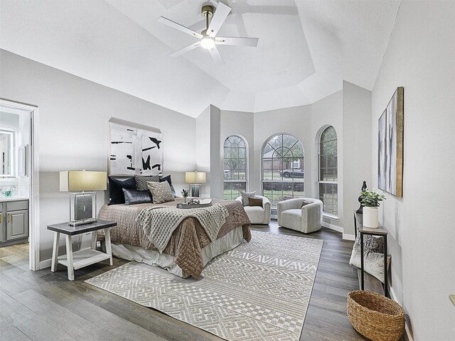 bedroom featuring hardwood / wood-style flooring, lofted ceiling, connected bathroom, and ceiling fan