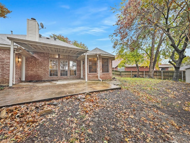 rear view of property with a sunroom and a patio area