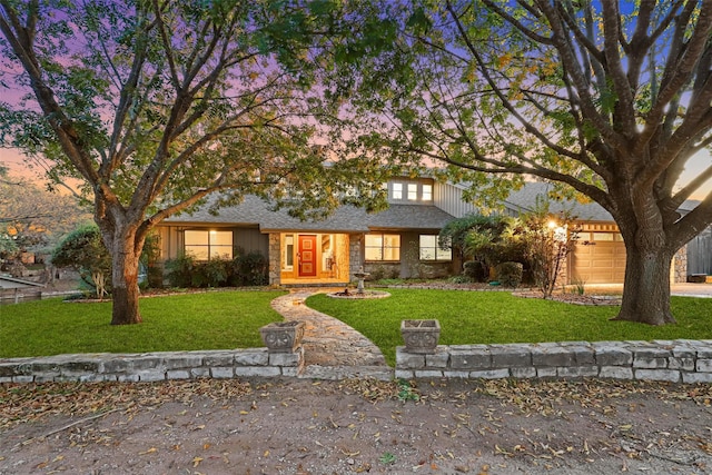 view of front of property featuring a lawn and a garage