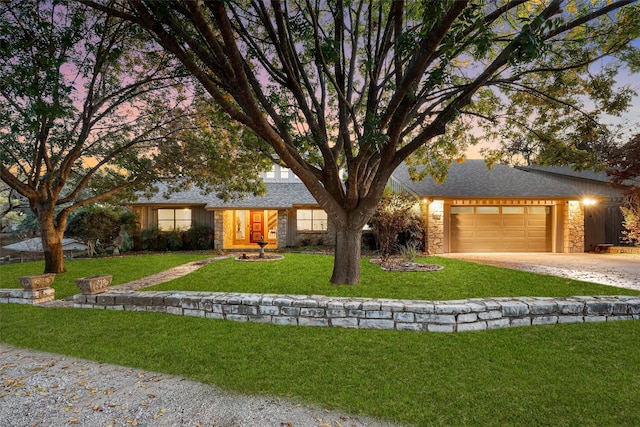 view of front of property with a garage and a yard