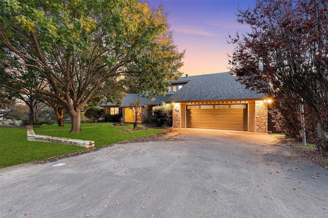 view of front of home with a garage and a yard