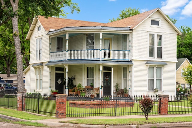 view of front facade featuring a balcony, covered porch, and a front yard