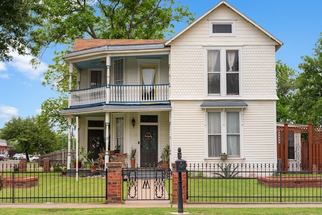 view of front facade featuring a porch, a balcony, and a front lawn