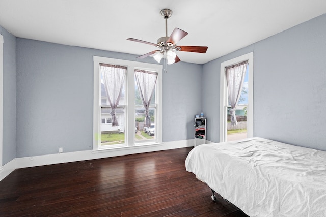 bedroom with multiple windows, ceiling fan, and wood-type flooring