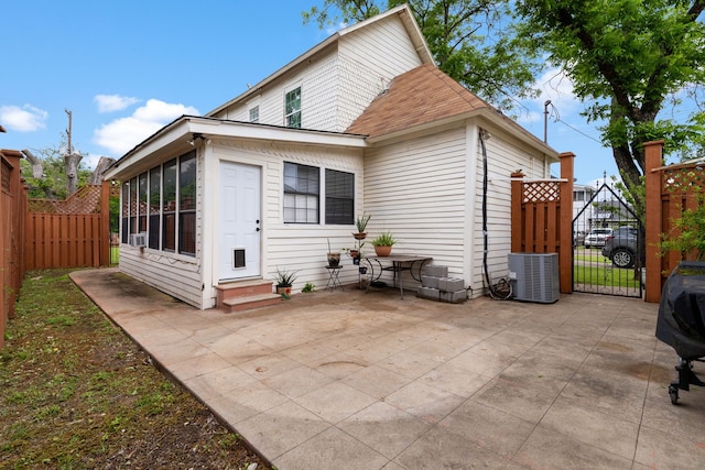 back of house with a sunroom, cooling unit, and a patio area