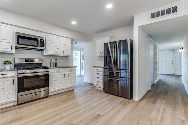 kitchen featuring decorative backsplash, stainless steel appliances, light hardwood / wood-style flooring, and white cabinetry