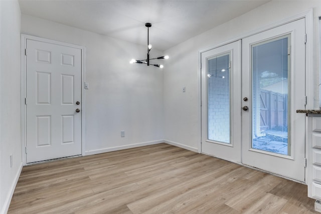 foyer entrance featuring a chandelier, french doors, and light hardwood / wood-style flooring