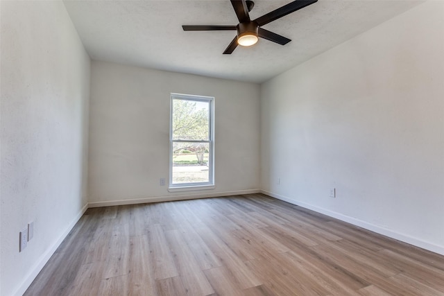 spare room featuring a textured ceiling, light wood-type flooring, and ceiling fan