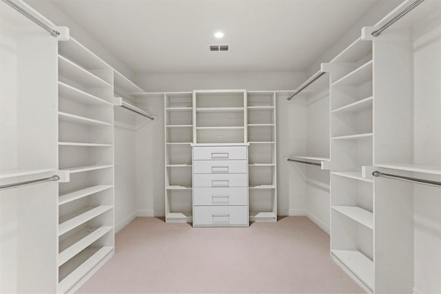 walk in closet featuring light carpet