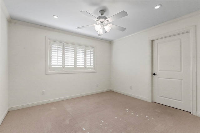 empty room featuring ceiling fan, light colored carpet, and ornamental molding