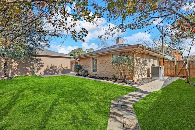 back of property featuring a yard and central AC