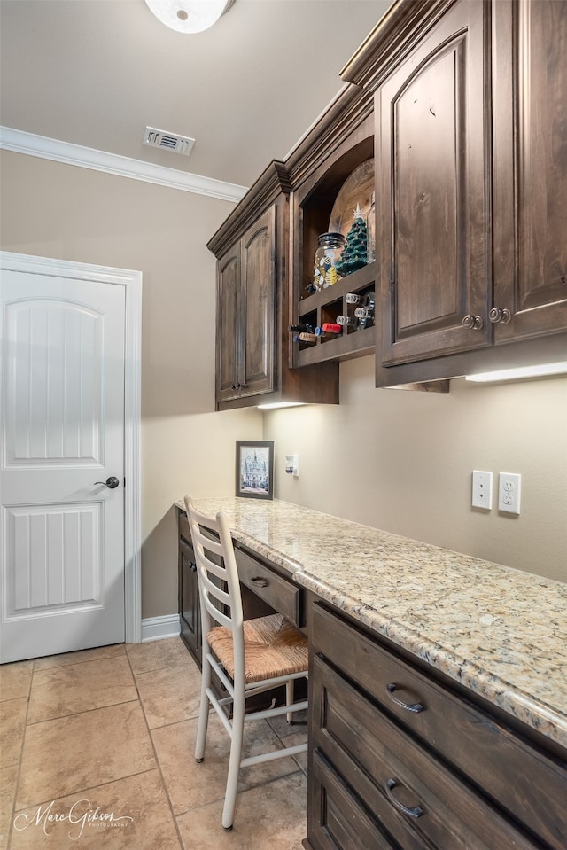 home office featuring light tile patterned floors, built in desk, and ornamental molding