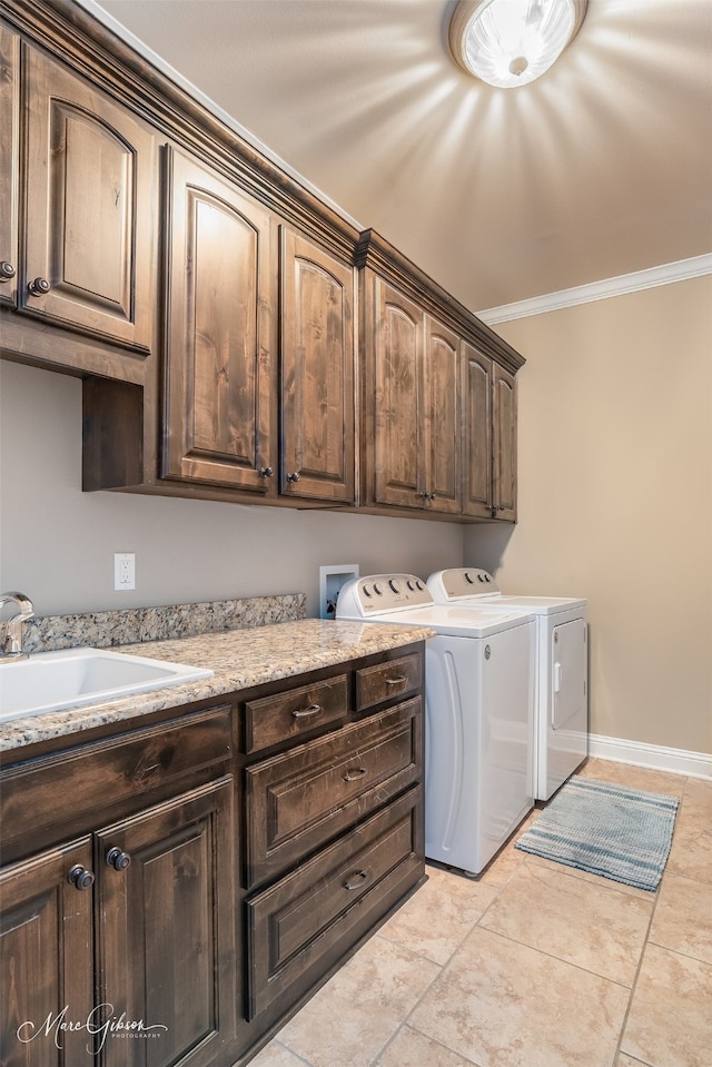 washroom with cabinets, sink, crown molding, washer and dryer, and light tile patterned floors