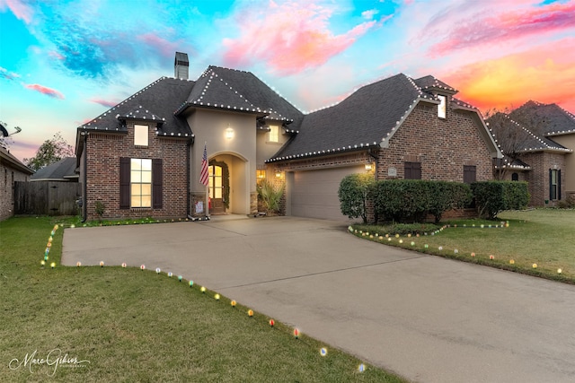 view of front of house featuring a garage and a yard