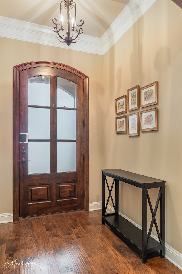 entryway with ornamental molding, dark hardwood / wood-style floors, and a notable chandelier