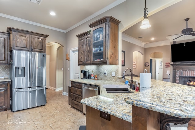 kitchen featuring decorative backsplash, kitchen peninsula, sink, and appliances with stainless steel finishes