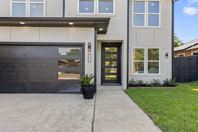 property entrance featuring a lawn and a garage