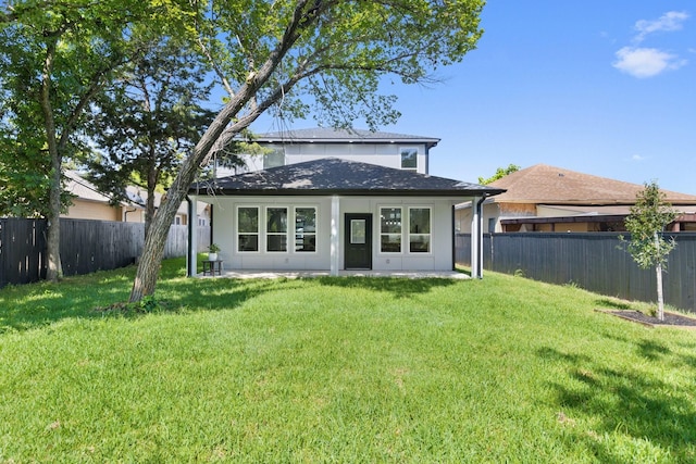 rear view of house featuring a yard