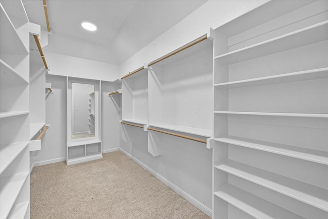 walk in closet featuring light colored carpet