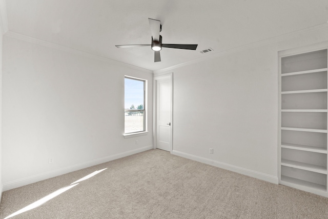 carpeted spare room with ornamental molding and ceiling fan