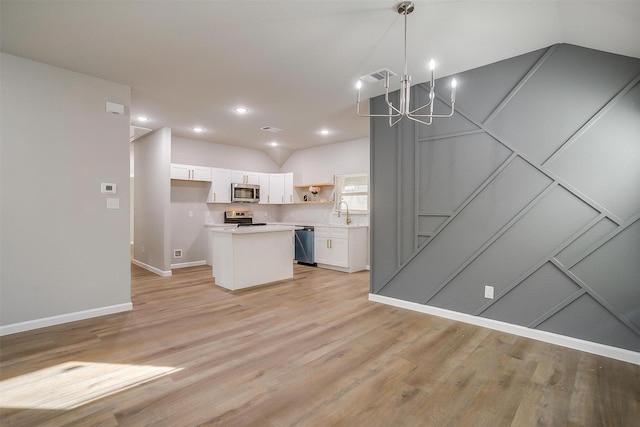 kitchen with pendant lighting, a center island, light wood-type flooring, white cabinetry, and stainless steel appliances