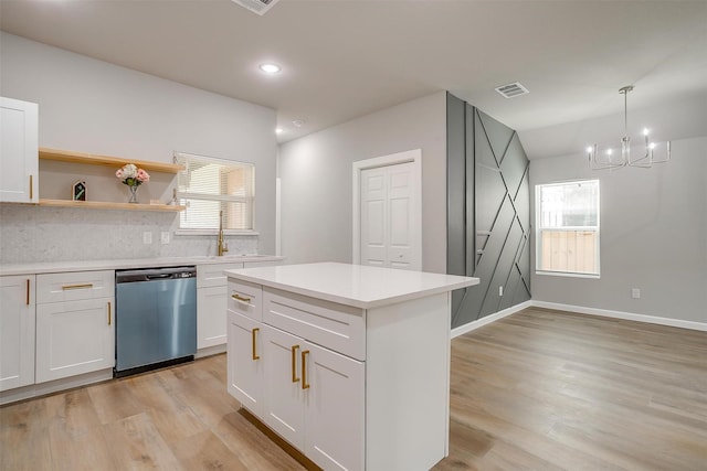 kitchen with stainless steel dishwasher, decorative light fixtures, white cabinets, and light wood-type flooring