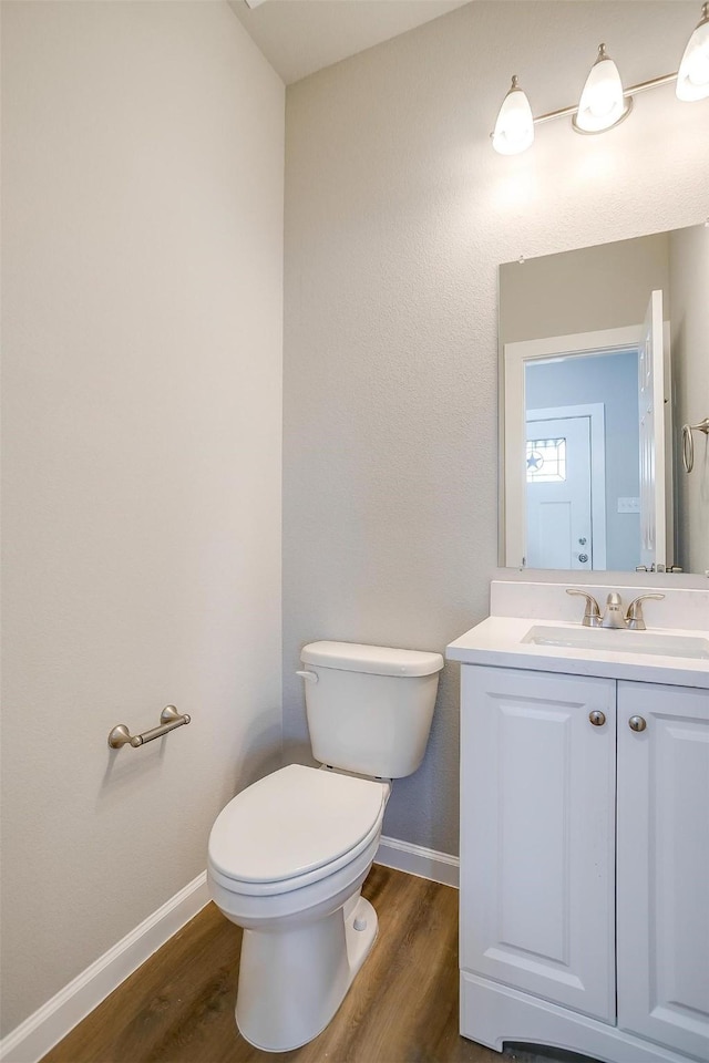 bathroom featuring vanity, toilet, and hardwood / wood-style floors