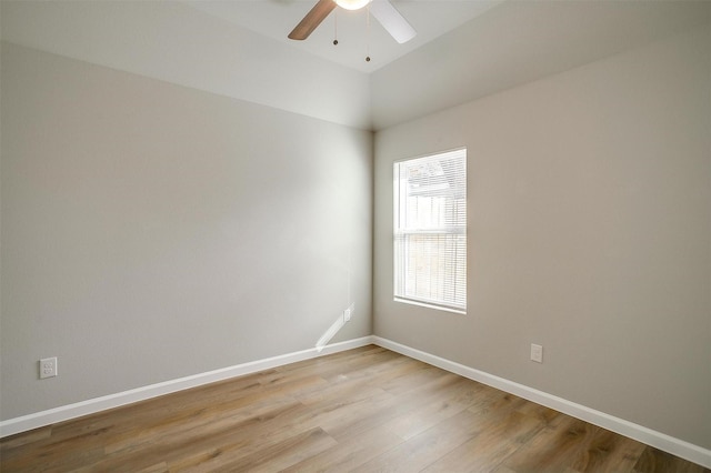 spare room with ceiling fan, vaulted ceiling, and light hardwood / wood-style flooring