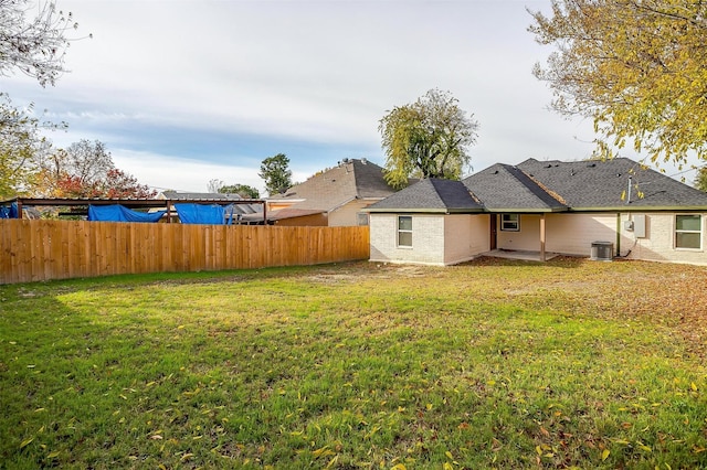 exterior space with central AC and a lawn