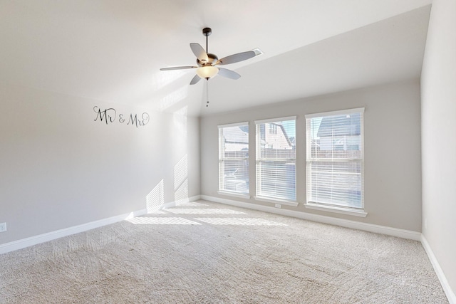 carpeted spare room with ceiling fan and lofted ceiling