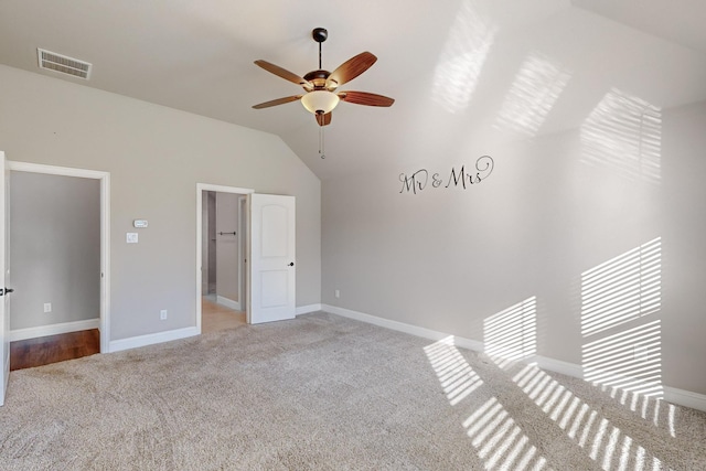 unfurnished bedroom with ceiling fan, light colored carpet, and vaulted ceiling