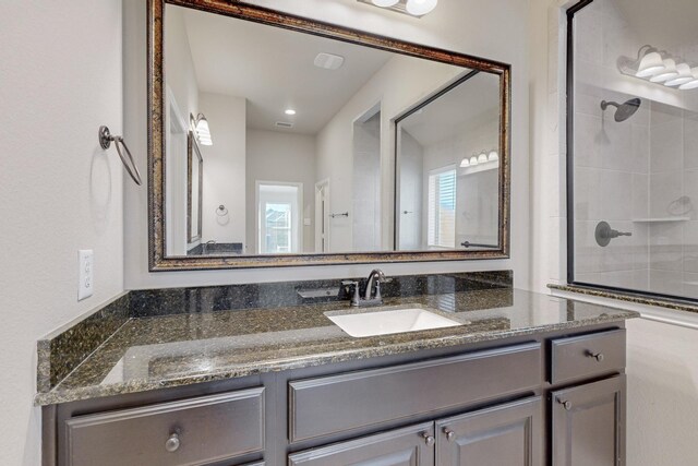 bathroom with vanity and a tile shower