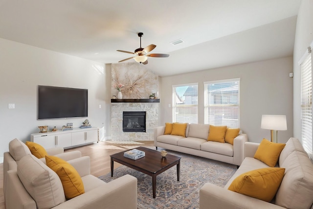 living room with lofted ceiling, a fireplace, ceiling fan, and light hardwood / wood-style flooring